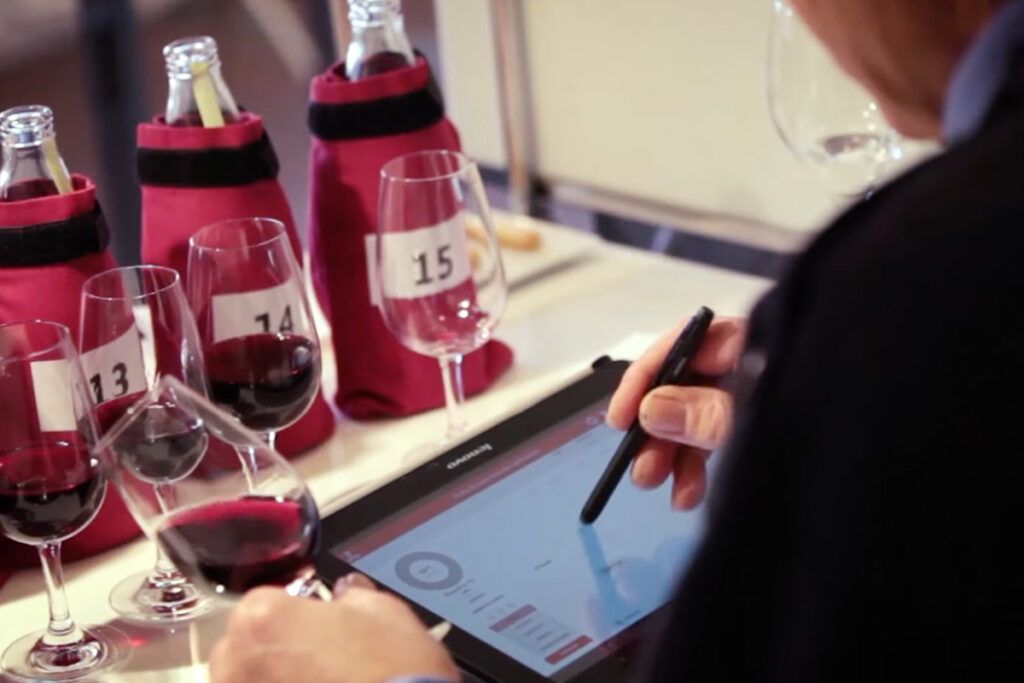 person using a tablet with a stylist, studying red wine