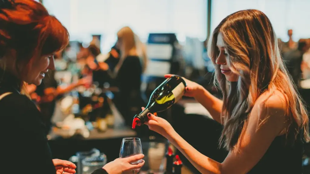 A woman pours wine at Winefest calgary